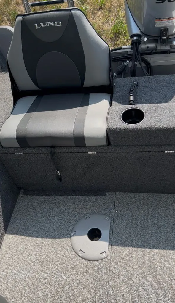 Slide: The Image of A seat and cup holder on a boat with gray carpeted flooring. - 6
