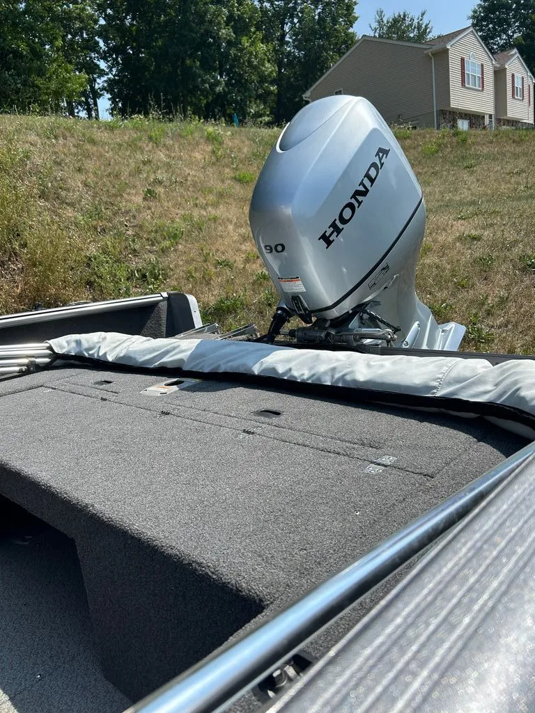 Slide: The Image of A 2019 Lund 1675 Impact SS with a Honda outboard motor, parked on a grassy hill. - 14