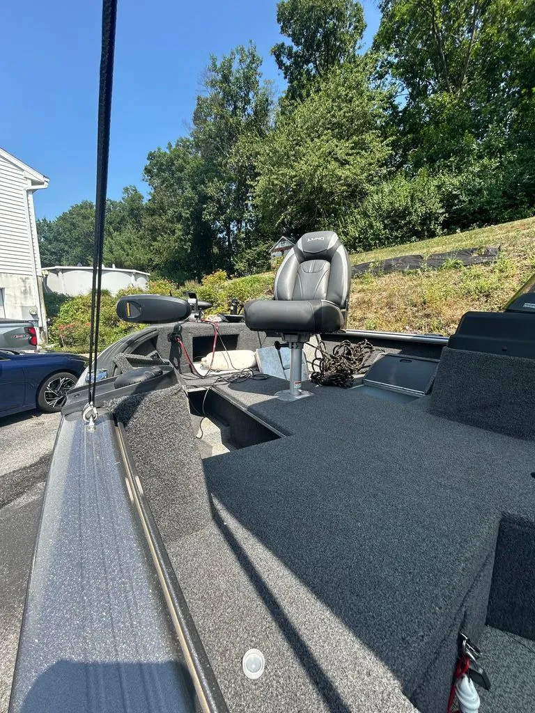 Slide: The Image of A 2019 Lund 1675 Impact SS boat with gray carpeting and an outdoor seat. - 7