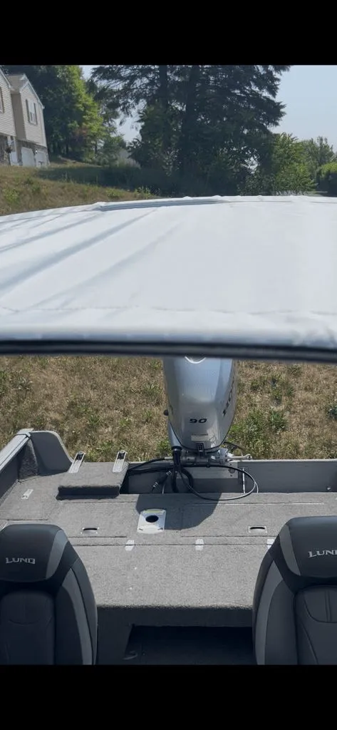 Slide: The Image of The image shows the interior of a 2019 Lund 1675 Impact SS boat with an outboard motor. - 13