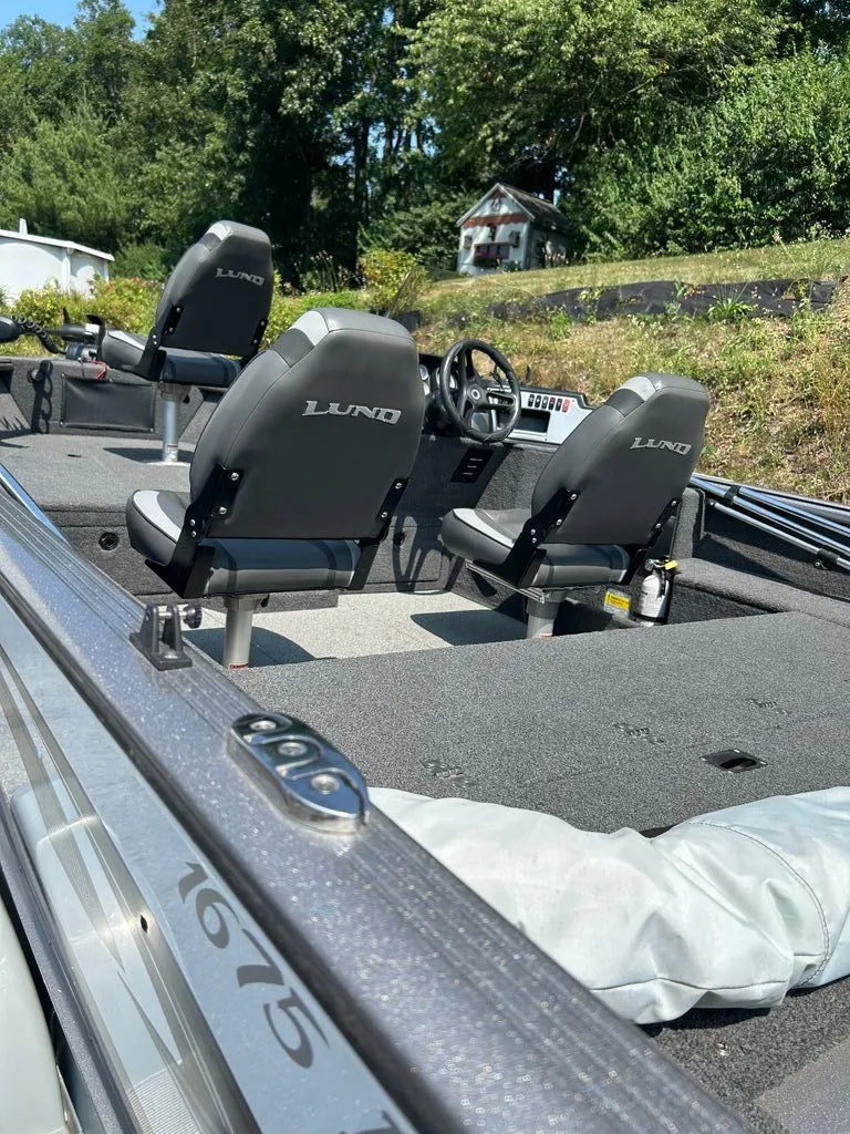 Slide: The Image of The image shows the interior of a 2019 Lund 1675 Impact SS boat with two seats. - 2
