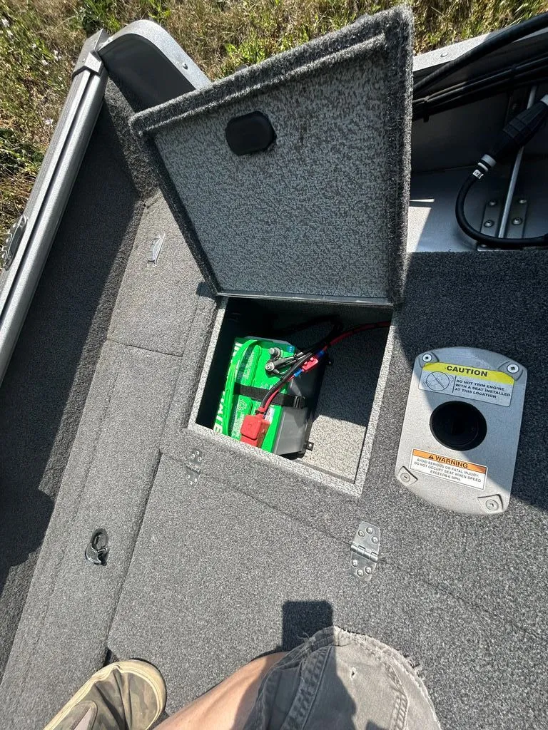 Slide: The Image of An open storage compartment on a boat reveals a battery and cables. - 11