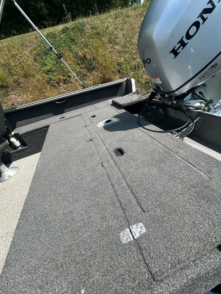 Slide: The Image of The image shows the deck of a 2019 Lund 1675 Impact SS boat with a Honda engine. - 15