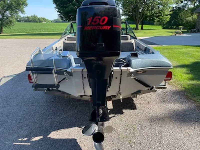 Slide: The Image of A 1984 Ebbtide Dyna-Trak boat with a Mercury 150 outboard motor, parked on a gravel path. - 11