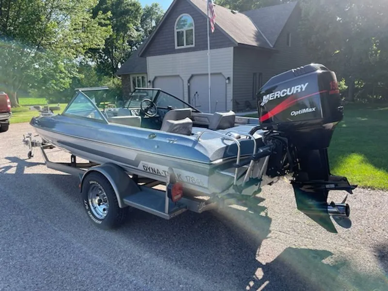 Slide: The Image of A 1984 Ebbtide Dyna-Trak boat on a trailer in front of a house. - 9