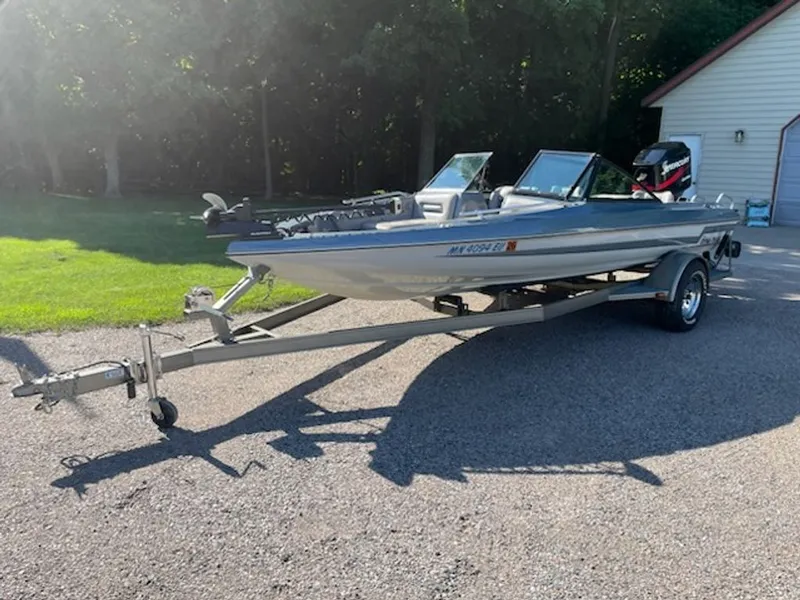 Slide: The Image of A 1984 Ebbtide Dyna-Trak boat on a trailer in a sunny driveway. - 5
