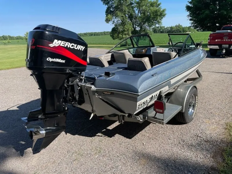 Slide: The Image of A 1984 Ebbtide Dyna-Trak boat with a Mercury outboard motor, parked on a trailer. - 10