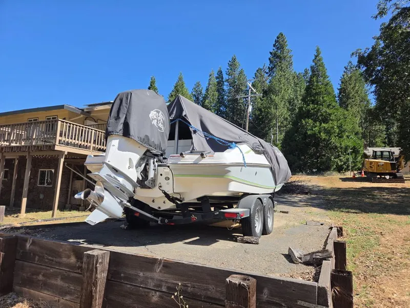 Slide: The Image of A 2018 Tahoe 2150 CC boat on a trailer in a wooded area. - 8