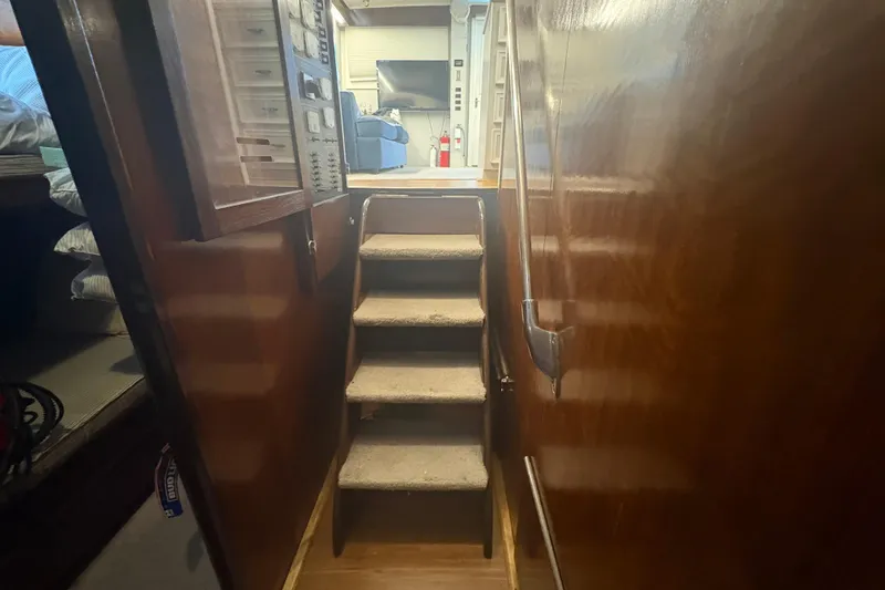 Slide: The Image of Interior stairs of a 1973 Hatteras 53 Convertible yacht, featuring wooden paneling. - 29