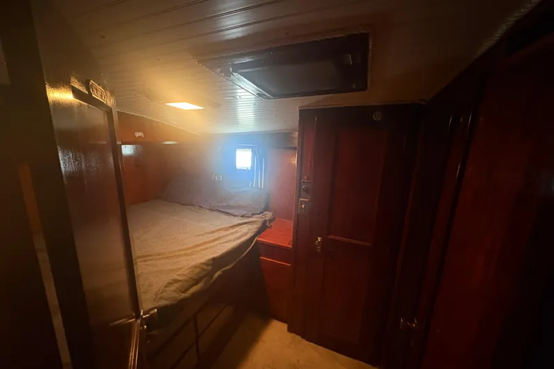 Slide: The Image of Interior cabin of a 1973 Hatteras 53 Convertible yacht with wooden paneling and a cozy bed. - 43