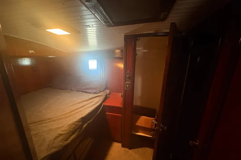 Slide: The Image of Cozy cabin interior of 1973 Hatteras 53 Convertible yacht with bed and wooden furnishings. - 43