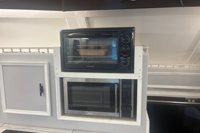 Slide: The Image of Kitchen appliances inside a 1973 Hatteras 53 Convertible yacht, featuring an oven and microwave. - 28