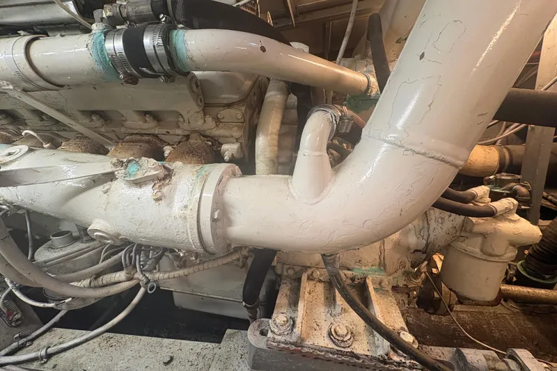 Slide: The Image of Engine room of a 1973 Hatteras 53 Convertible boat, showing pipes and machinery. - 110