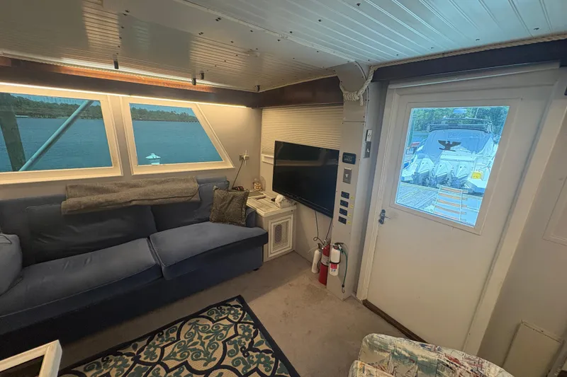 Slide: The Image of Interior of a 1973 Hatteras 53 Convertible yacht with cozy seating and a waterfront view. - 25