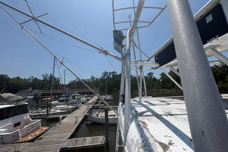 Slide: The Image of 1973 Hatteras 53 Convertible yacht docked at a marina under clear blue skies. - 82