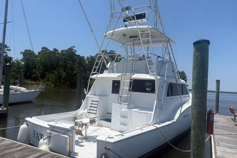 Slide: The Image of 1973 Hatteras 53 Convertible yacht docked at a marina under clear blue skies. - 8