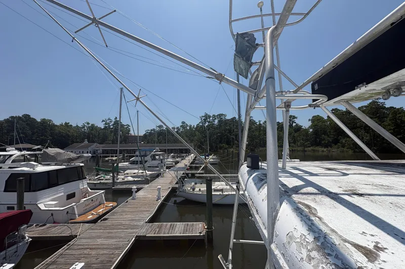 Slide: The Image of 1973 Hatteras 53 Convertible yacht docked at a marina under clear blue skies. - 84