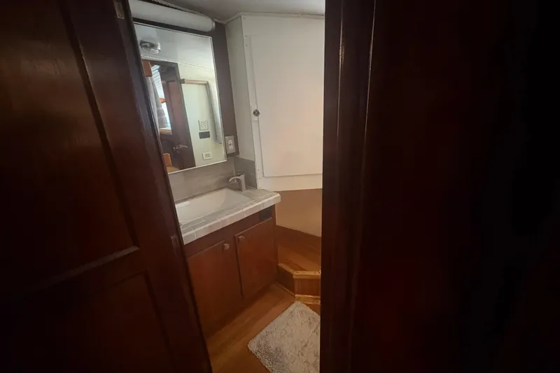 Slide: The Image of Interior bathroom of 1973 Hatteras 53 Convertible yacht with wooden cabinetry and sink. - 48