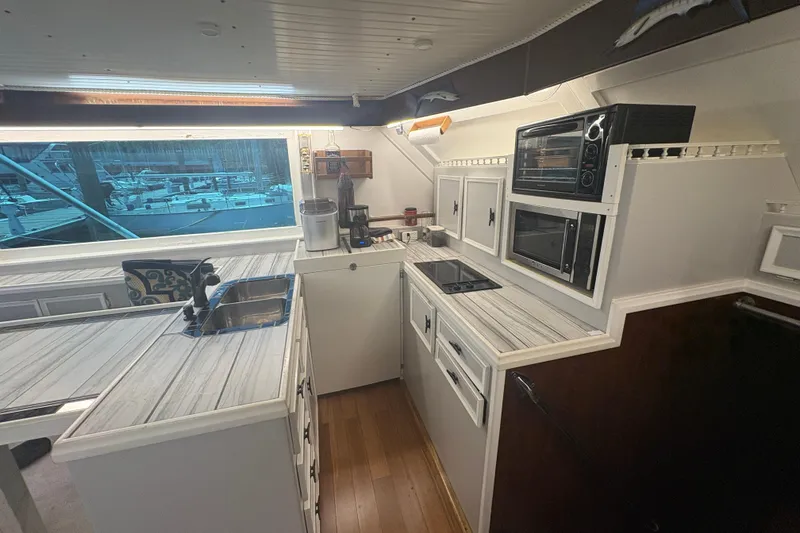 Slide: The Image of Interior of 1973 Hatteras 53 Convertible yacht kitchen with modern appliances and wood flooring. - 26