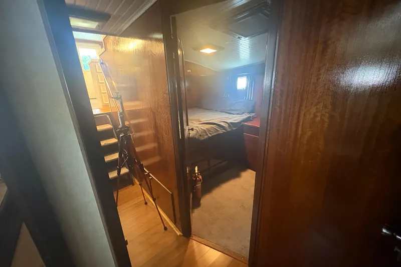 Slide: The Image of Interior of a 1973 Hatteras 53 Convertible yacht, featuring a cozy cabin with wooden finishes. - 63