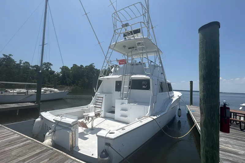 Slide: The Image of 1973 Hatteras 53 Convertible yacht docked at marina under clear blue sky. - 3