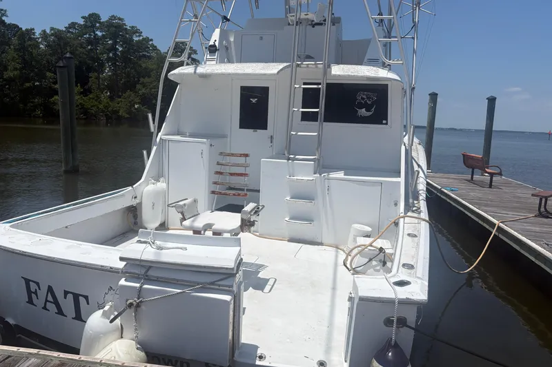 Slide: The Image of 1973 Hatteras 53 Convertible yacht docked by a serene waterfront. - 10