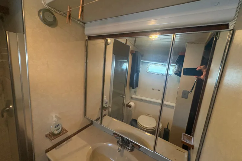 Slide: The Image of Bathroom interior of a 1973 Hatteras 53 Convertible yacht with mirrored cabinets. - 54