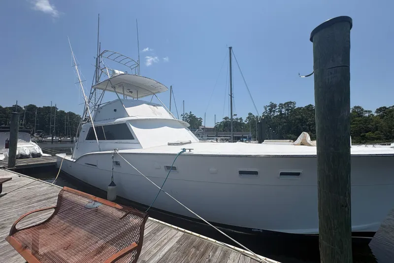 Slide: The Image of 1973 Hatteras 53 Convertible yacht docked at a marina under clear skies. - 8