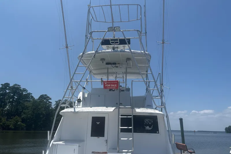 Slide: The Image of 1973 Hatteras 53 Convertible yacht for sale, docked under clear blue sky. - 4
