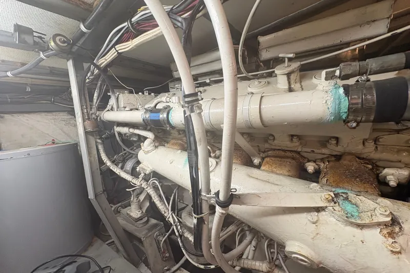 Slide: The Image of Engine room of a 1973 Hatteras 53 Convertible boat, showing detailed machinery and wiring. - 110