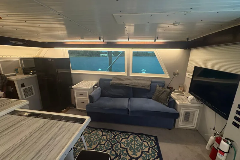 Slide: The Image of Interior of a 1973 Hatteras 53 Convertible yacht with sofa, TV, and kitchen area. - 23