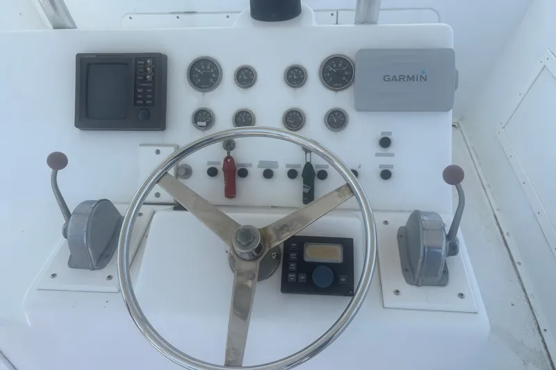 Slide: The Image of 1973 Hatteras 53 Convertible helm with steering wheel, gauges, and Garmin navigation system. - 71