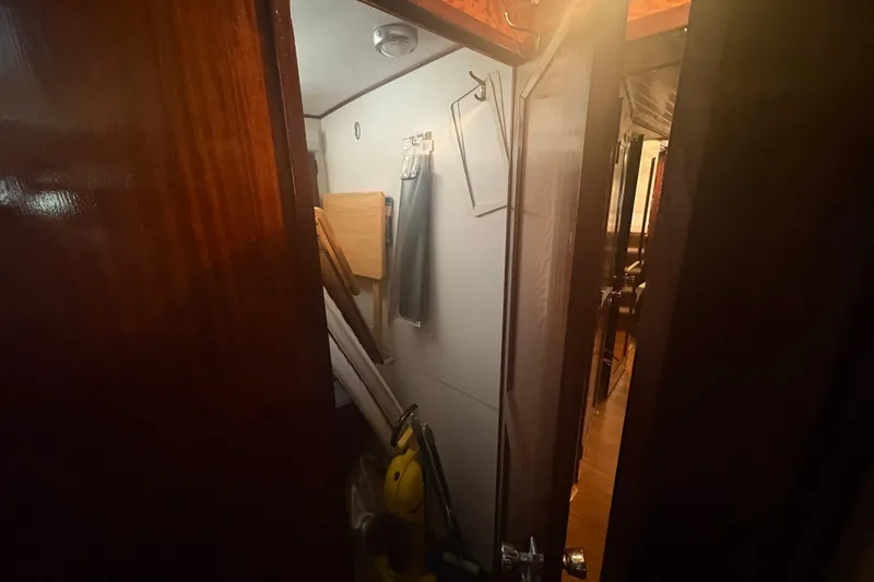 Slide: The Image of Interior view of a 1973 Hatteras 53 Convertible yacht, featuring wooden paneling and storage space. - 41