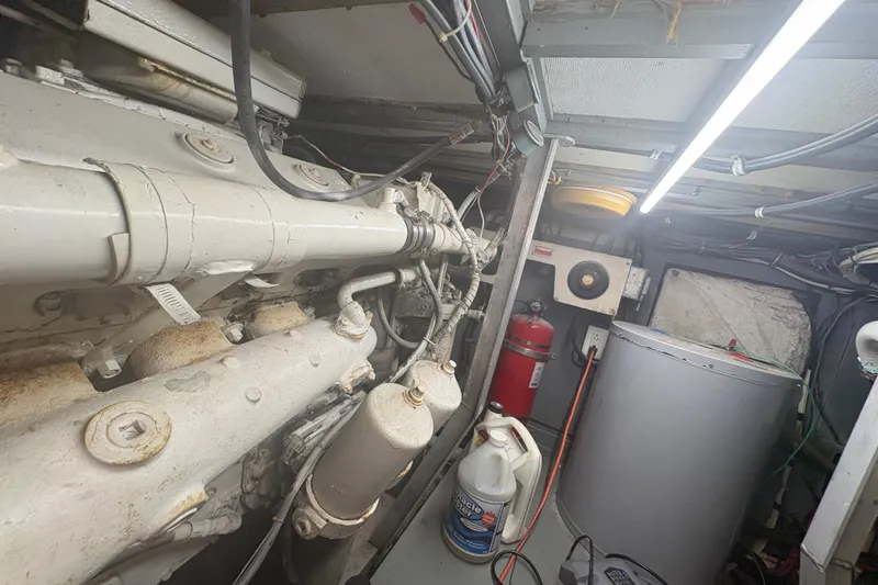 Slide: The Image of Engine room of a 1973 Hatteras 53 Convertible boat, featuring machinery and equipment. - 101