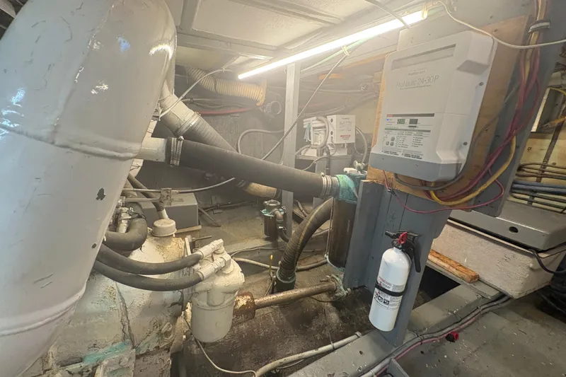 Slide: The Image of Engine room of a 1973 Hatteras 53 Convertible boat, featuring mechanical components and wiring. - 105