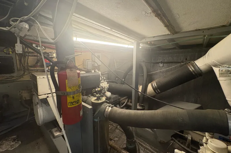 Slide: The Image of Engine room of a 1973 Hatteras 53 Convertible with visible fire extinguisher and machinery. - 109