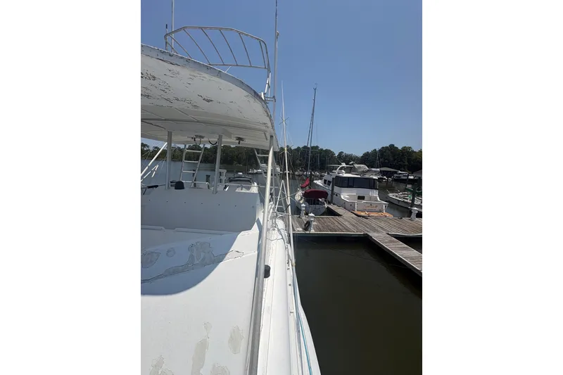 Slide: The Image of 1973 Hatteras 53 Convertible yacht docked at marina under clear blue sky. - 80