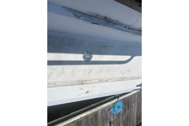 Slide: The Image of 1973 Hatteras 53 Convertible boat detail with visible wear and blue rope. - 99