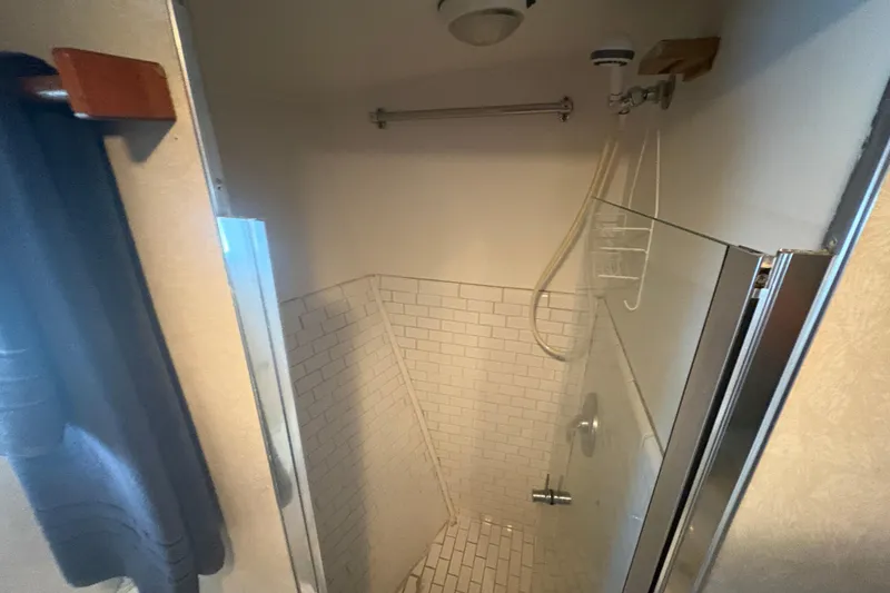 Slide: The Image of Shower area in a 1973 Hatteras 53 Convertible yacht with tiled walls and glass door. - 54