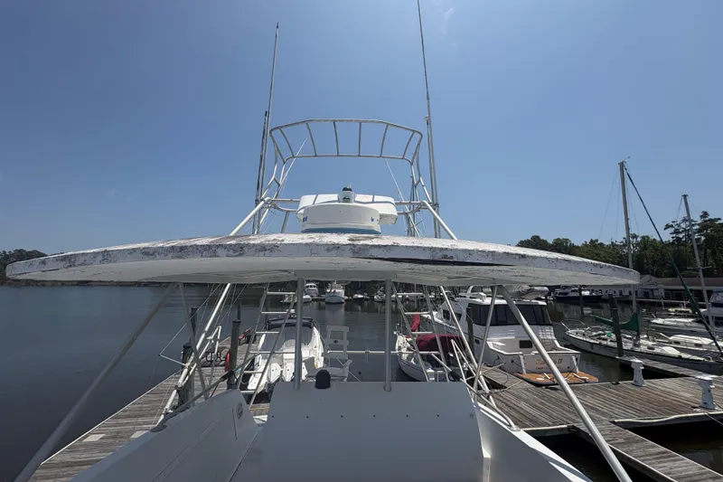 Slide: The Image of 1973 Hatteras 53 Convertible yacht docked at marina under clear blue sky. - 78