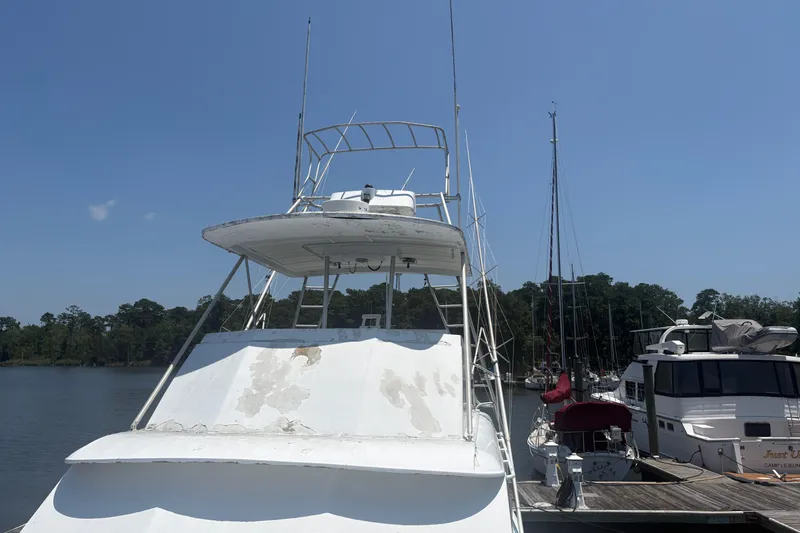 Slide: The Image of 1973 Hatteras 53 Convertible yacht docked at marina under clear blue sky. - 78