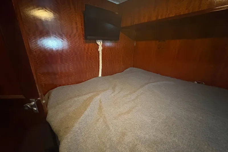Slide: The Image of Interior cabin of a 1973 Hatteras 53 Convertible yacht with wood paneling and a mounted TV. - 45