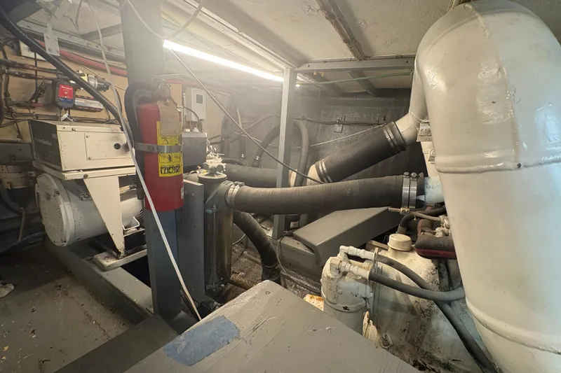 Slide: The Image of Engine room of a 1973 Hatteras 53 Convertible yacht, featuring machinery and equipment. - 104