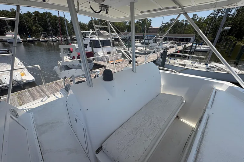 Slide: The Image of 1973 Hatteras 53 Convertible yacht interior with marina view, featuring seating and helm station. - 74