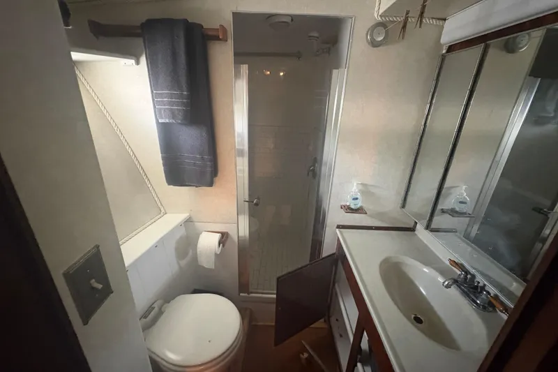 Slide: The Image of Bathroom interior of 1973 Hatteras 53 Convertible yacht with shower, sink, and toilet. - 51