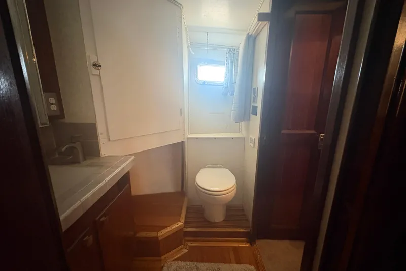 Slide: The Image of Bathroom interior of a 1973 Hatteras 53 Convertible yacht, featuring a toilet and sink. - 49