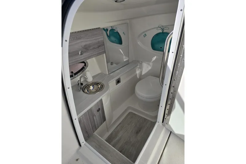 Slide: The Image of 2020 Formula 310 Bowrider OB boat bathroom with sink, toilet, and decorative accents. - 14