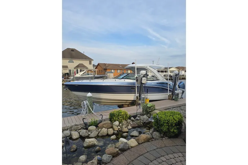 Slide: The Image of 2020 Formula 310 Bowrider OB docked by waterfront homes, showcasing sleek design and modern features. - 15