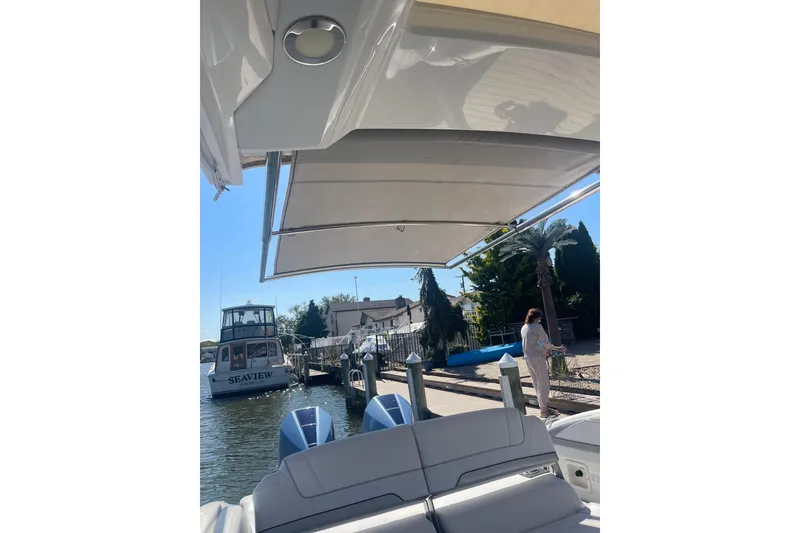 Slide: The Image of 2020 Formula 310 Bowrider OB docked, featuring a retractable canopy and dual outboard engines. - 17