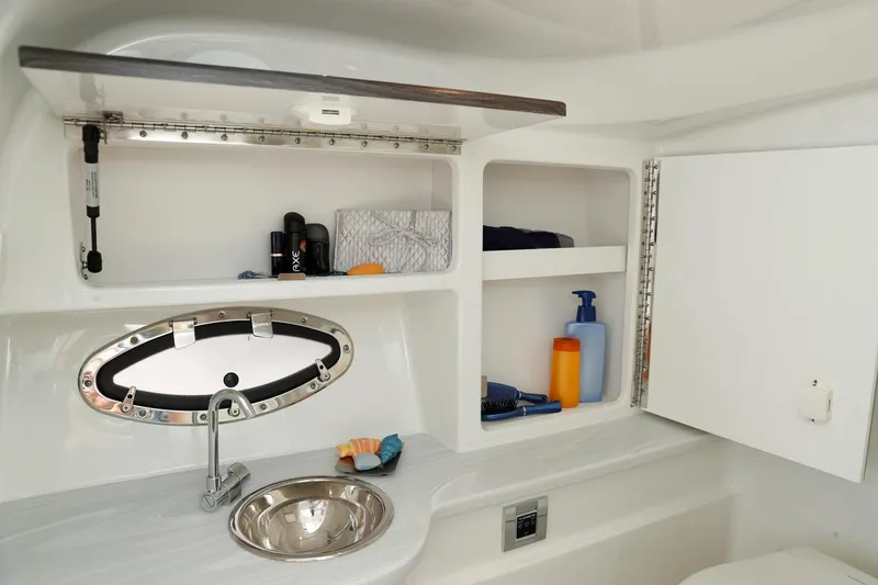 Slide: The Image of Manufacturer Provided Image: 2021 Formula 310 Bowrider OB bathroom with sink, storage shelves, and porthole window. - 21